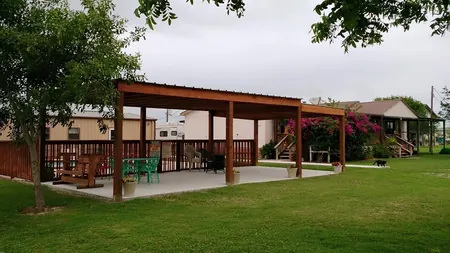 The covered pavilion beside the clubhouse with tables and chairs