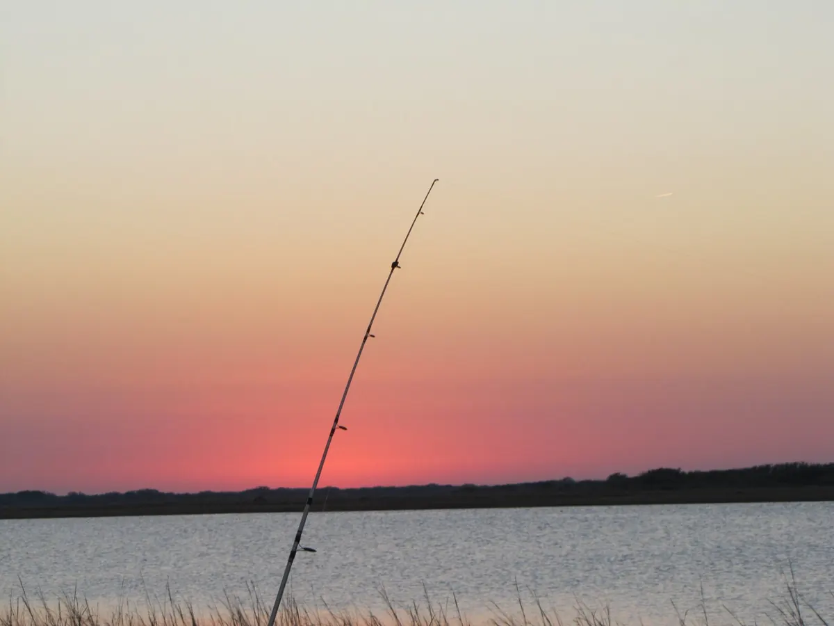 A fishing rod silhouetted against a Port O'Connor sunset