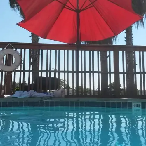 The swimming pool with a red umbrella at Beacon 44 RV Park
